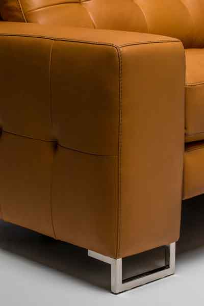 Close-up detail of Hudson arm, chrome foot and tufting detail. High-style motion furniture.